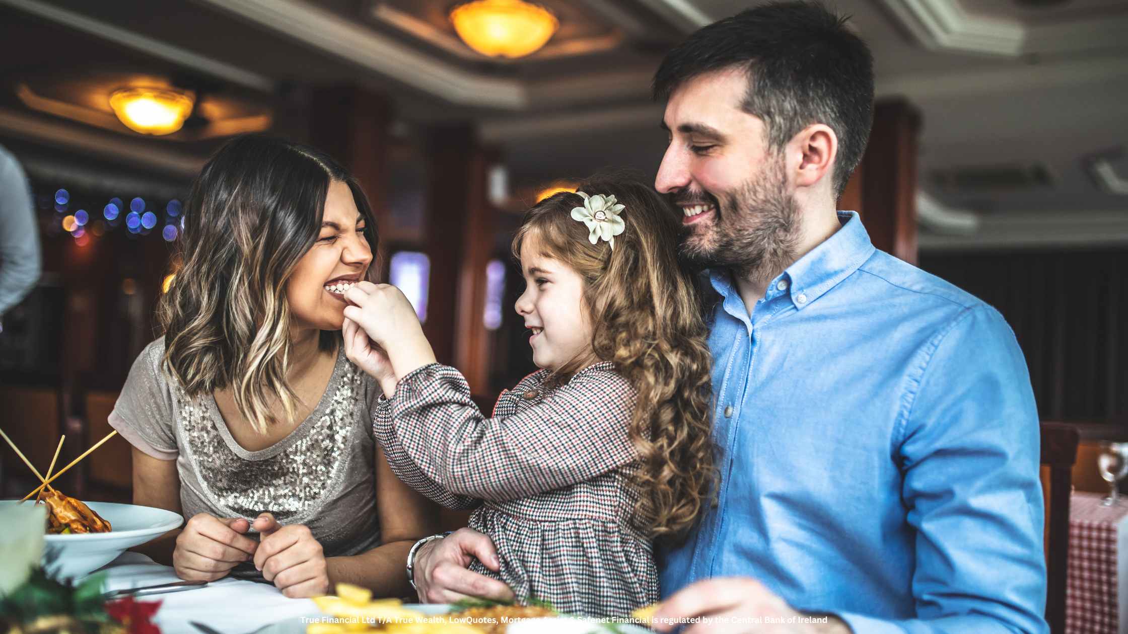 happy little girl feeds mother while father observes